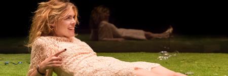 Billie Piper lying on a stage of grass in Yerma. Photo by Johan Persson.